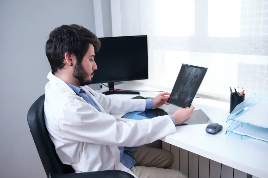 young doctor examining x ray of hips and spine for 2022 08 17 18 21 45 utc